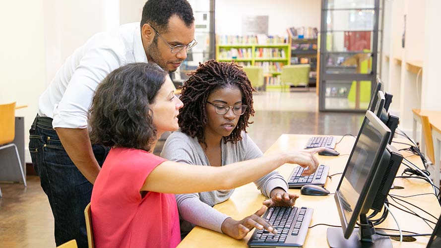 Teachers discussing items on a screen