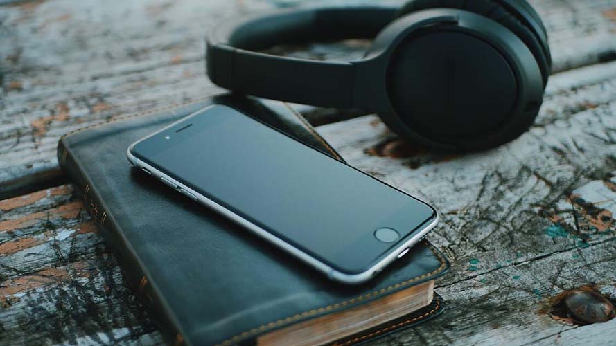 Book, smartphone and headphones on a desk