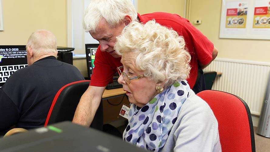 Charity worker with showing a client how to use GuideConnect technology