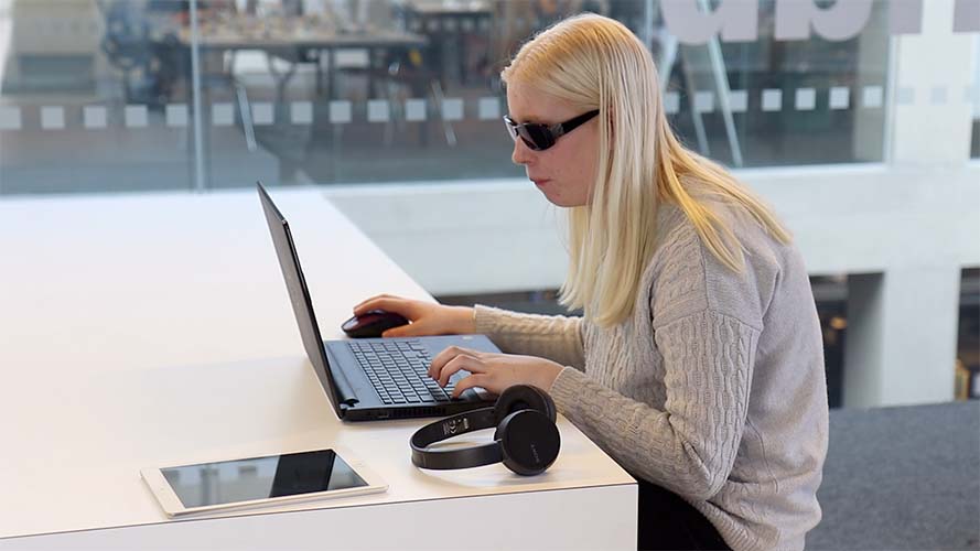 Student using SuperNova on her laptop in a library.