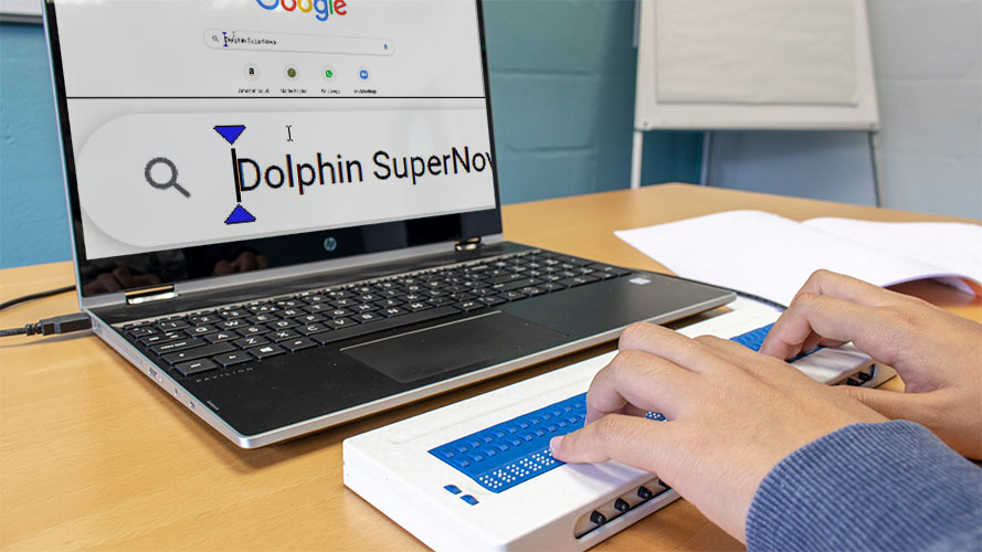 A user reading the laptop screen using a Braille display and SuperNova.