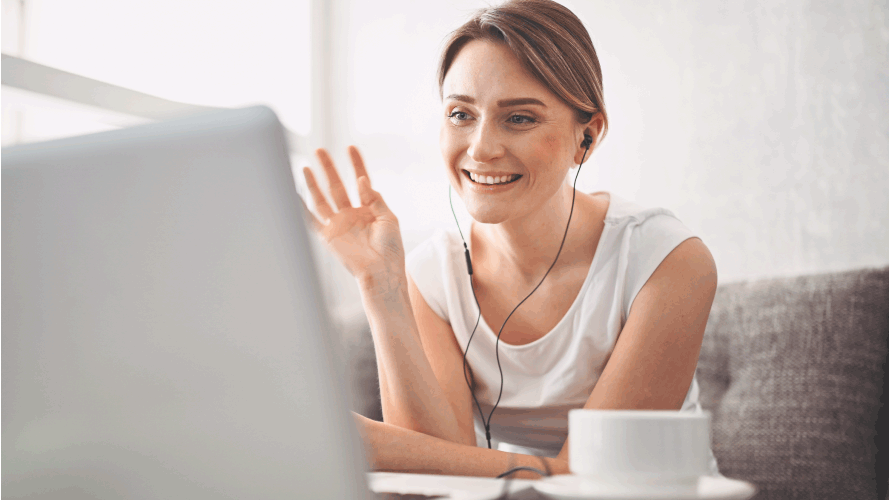 Young, happy woman using a laptop at home, to video call.