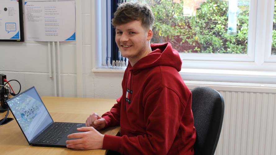 Jake at his desk, smiling